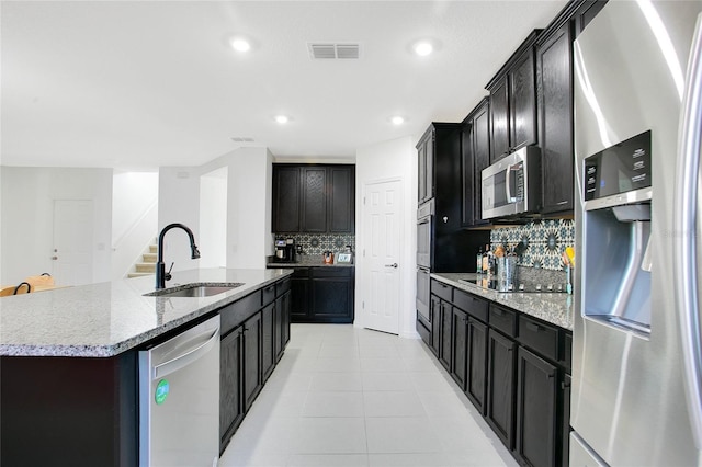 161 Williamson Dr, Davenport, FL 33897 - kitchen with appliances with stainless steel finishes, visible vents, a sink, backsplash, and an island with sink