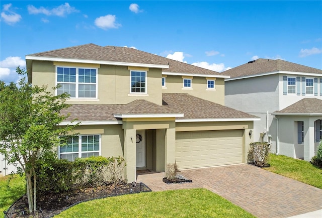 161 Williamson Dr, Davenport, FL 33897 - traditional-style house with roof with shingles, stucco siding, decorative driveway, and a front yard