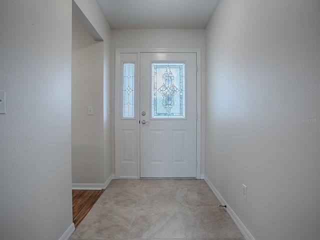 foyer entrance featuring baseboards