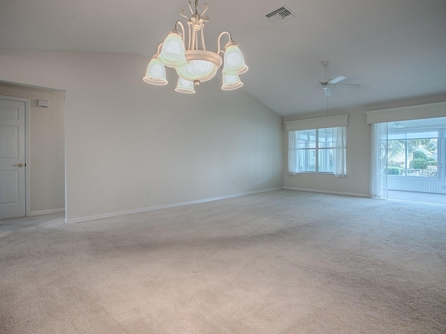 empty room with lofted ceiling, light colored carpet, ceiling fan with notable chandelier, baseboards, and visible vents