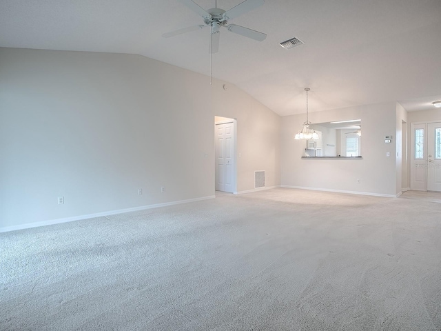 spare room featuring lofted ceiling, visible vents, ceiling fan with notable chandelier, and light colored carpet