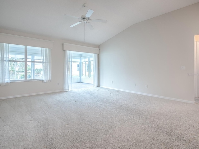 carpeted empty room with baseboards, vaulted ceiling, and a ceiling fan