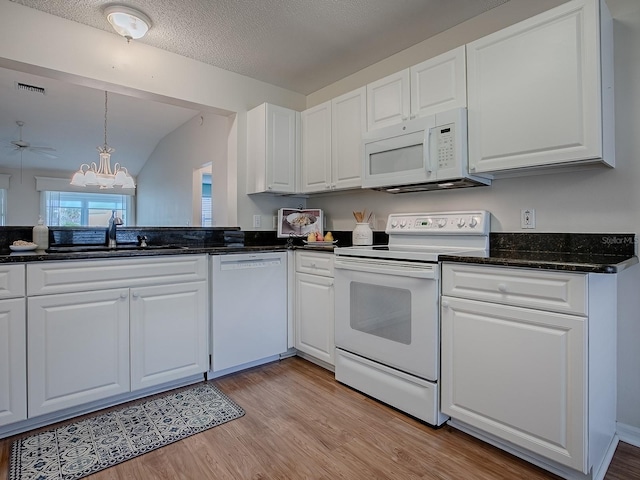 kitchen featuring white appliances, white cabinetry, and a sink