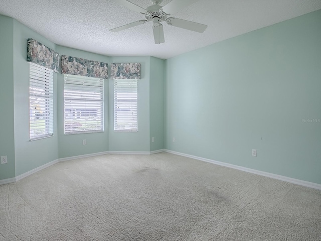 spare room with baseboards, carpet flooring, a textured ceiling, and ceiling fan