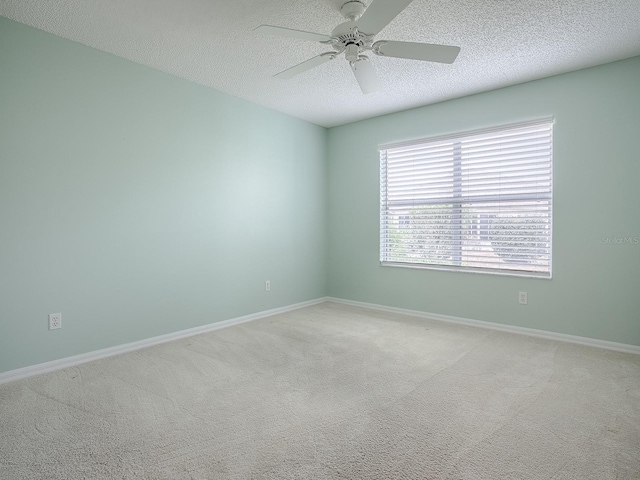 unfurnished room with baseboards, a textured ceiling, carpet, and a ceiling fan