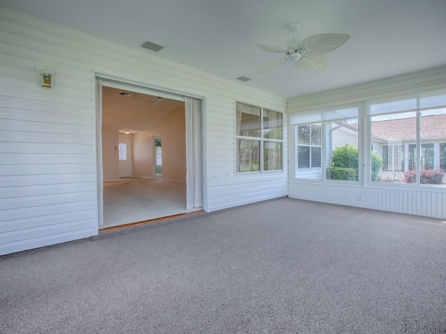 unfurnished sunroom featuring visible vents and a ceiling fan