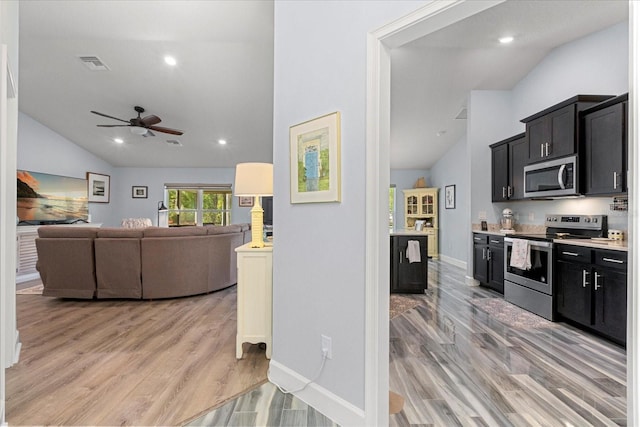 kitchen featuring visible vents, vaulted ceiling, a ceiling fan, and appliances with stainless steel finishes