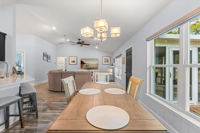 dining area with baseboards, lofted ceiling, wood finished floors, and ceiling fan