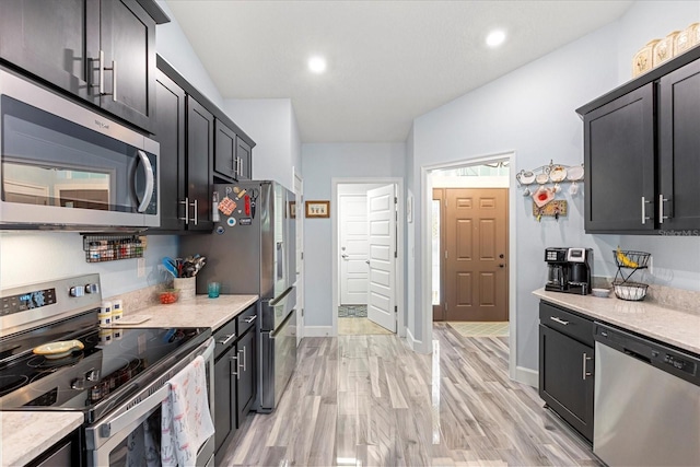 kitchen with baseboards, light wood-style floors, recessed lighting, and stainless steel appliances