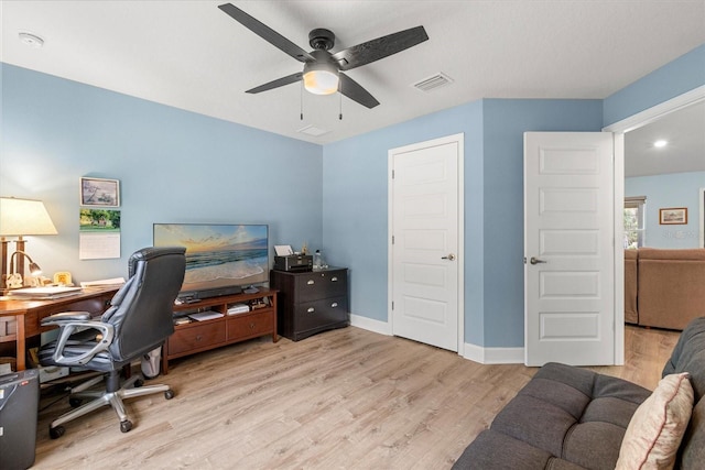 office space featuring baseboards, visible vents, wood finished floors, and ceiling fan
