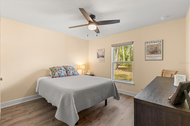 bedroom featuring baseboards, ceiling fan, and wood finished floors