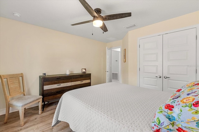 bedroom featuring visible vents, a closet, light wood-style floors, and a ceiling fan