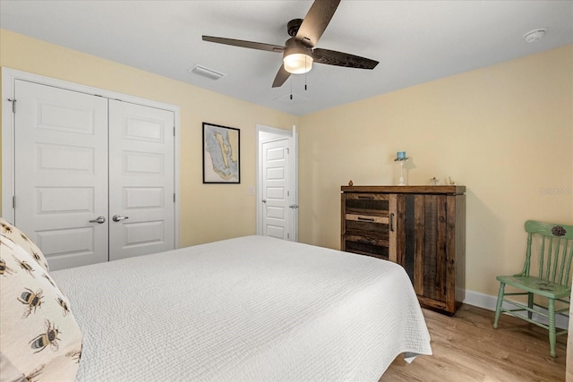 bedroom with a closet, light wood-type flooring, baseboards, visible vents, and ceiling fan