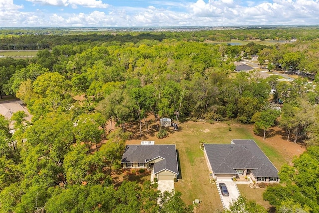 birds eye view of property featuring a forest view