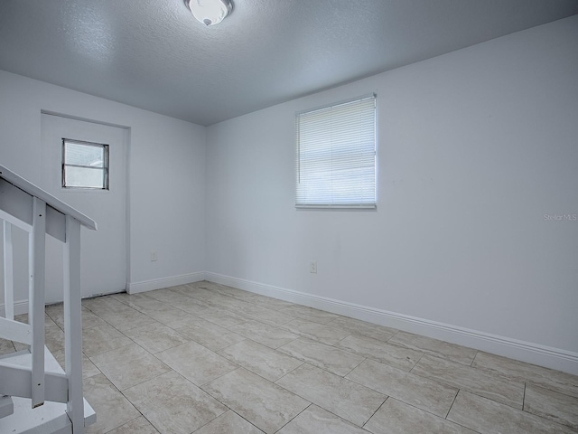 8901 SE 144th Ln, Summerfield, FL 34491 - spare room featuring stairway, baseboards, and a textured ceiling