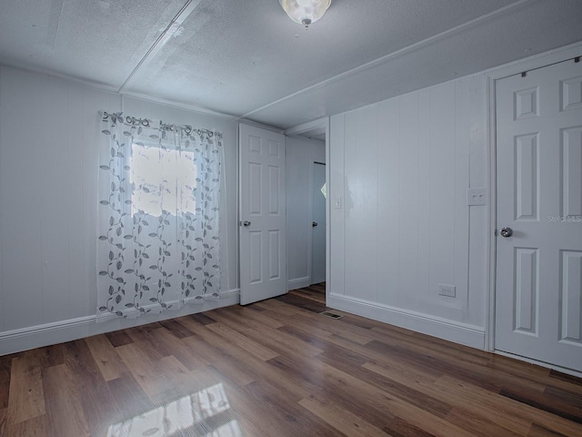 8901 SE 144th Ln, Summerfield, FL 34491 - unfurnished bedroom featuring a textured ceiling, wood finished floors, and baseboards