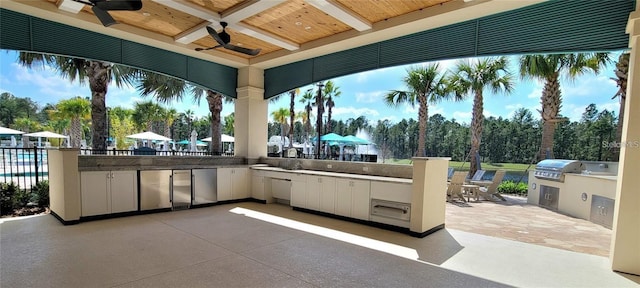 view of patio / terrace with a grill, an outdoor kitchen, and a ceiling fan