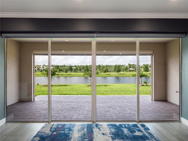 doorway featuring baseboards, wood finished floors, a water view, and ornamental molding