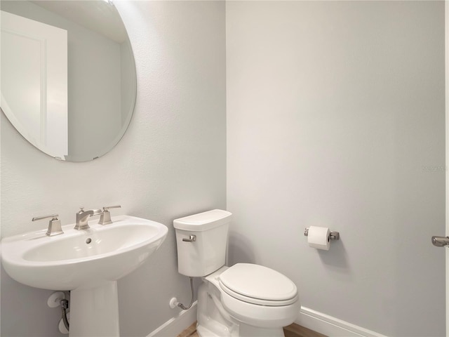 bathroom with toilet and baseboards
