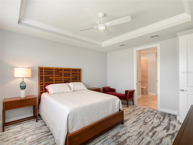 bedroom with wood finished floors, baseboards, visible vents, a raised ceiling, and a ceiling fan