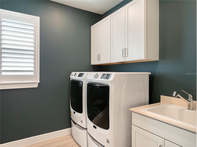 laundry area with a sink, cabinet space, and washer and clothes dryer
