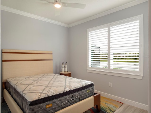 bedroom with ceiling fan, wood finished floors, baseboards, and ornamental molding