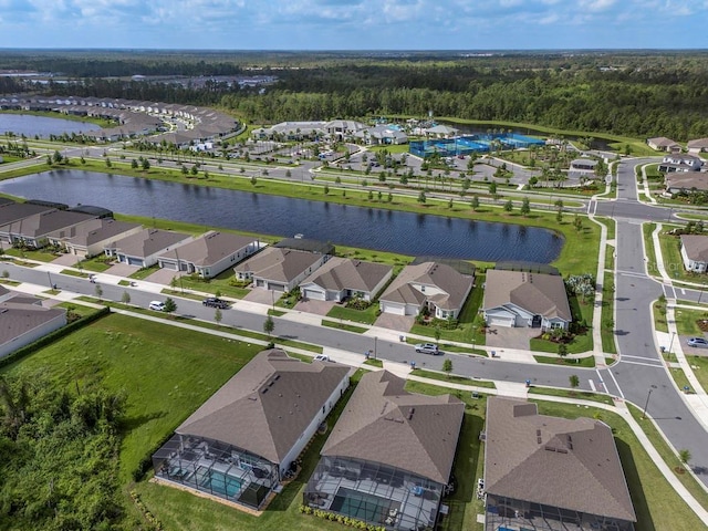 drone / aerial view featuring a water view, a forest view, and a residential view
