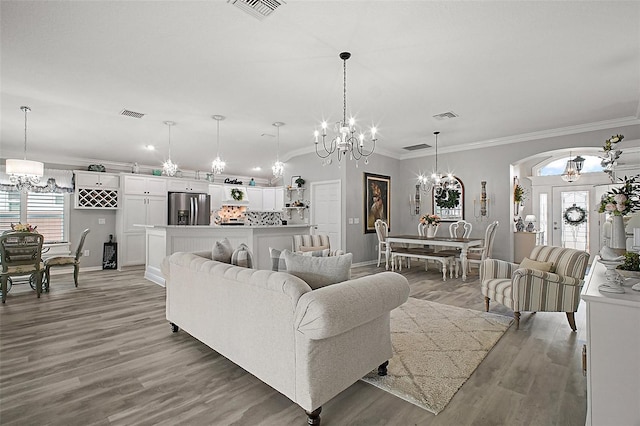3354 Truluck Pl, Oxford, FL 34484 - living room featuring arched walkways, a wealth of natural light, visible vents, and a chandelier