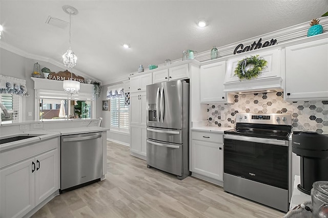 3354 Truluck Pl, Oxford, FL 34484 - kitchen with appliances with stainless steel finishes, lofted ceiling, white cabinetry, a sink, and a notable chandelier