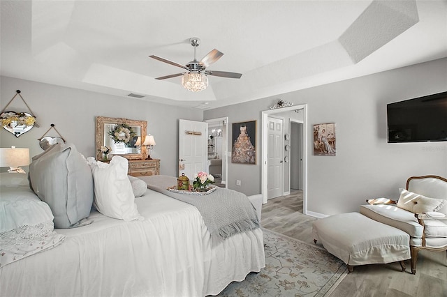 3354 Truluck Pl, Oxford, FL 34484 - bedroom featuring a tray ceiling, light wood-type flooring, baseboards, visible vents, and a ceiling fan