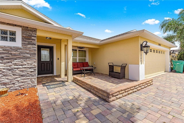 10460 Silver Maple Ave, Oxford, FL 34484 - entrance to property with an attached garage, stucco siding, stone siding, covered porch, and driveway