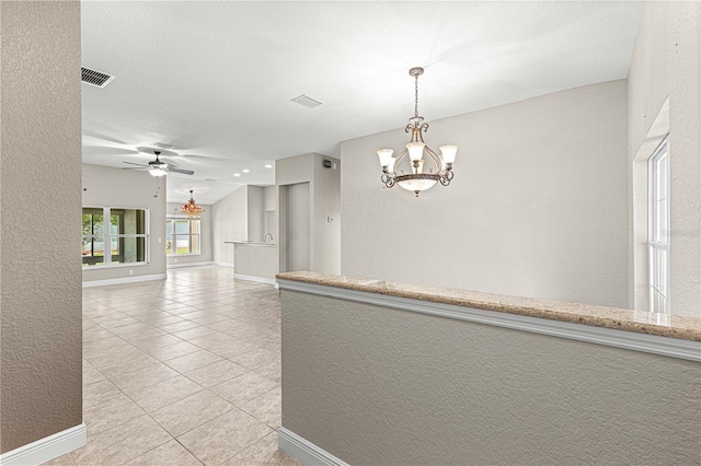 10460 Silver Maple Ave, Oxford, FL 34484 - empty room with a chandelier, light tile patterned floors, a ceiling fan, baseboards, and a textured wall