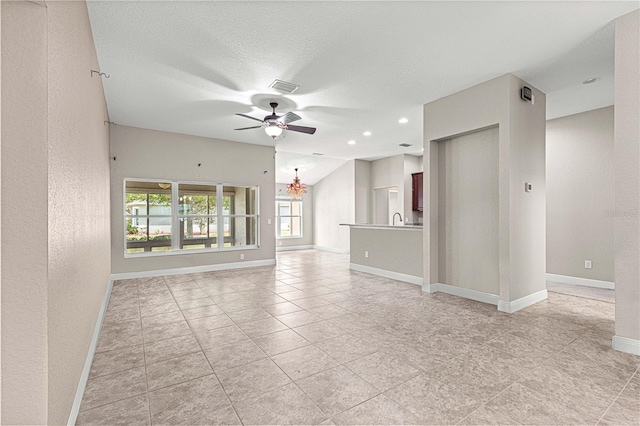 10460 Silver Maple Ave, Oxford, FL 34484 - unfurnished living room with a textured wall, ceiling fan, baseboards, a chandelier, and a textured ceiling