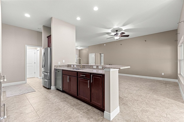 10460 Silver Maple Ave, Oxford, FL 34484 - kitchen with appliances with stainless steel finishes, a sink, ceiling fan, a peninsula, and light stone counters