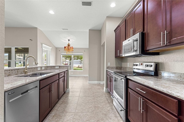 10460 Silver Maple Ave, Oxford, FL 34484 - kitchen with stainless steel appliances, a sink, a chandelier, baseboards, and light stone counters