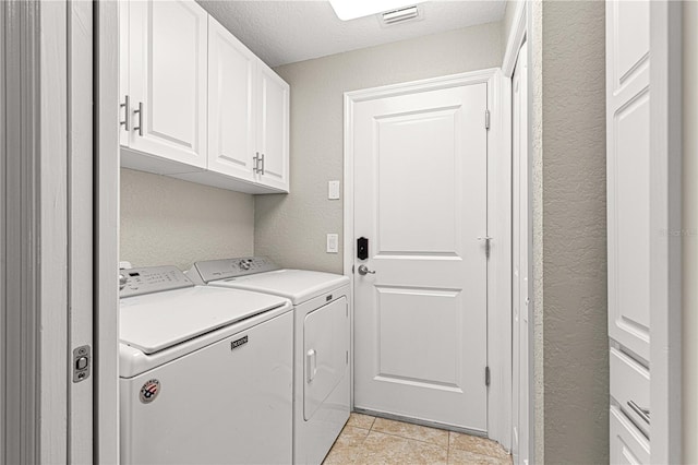 10460 Silver Maple Ave, Oxford, FL 34484 - laundry area with separate washer and dryer, cabinet space, light tile patterned floors, a textured wall, and a textured ceiling