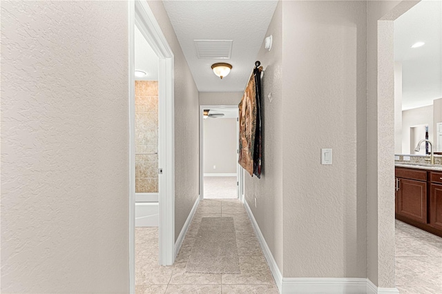 10460 Silver Maple Ave, Oxford, FL 34484 - hall featuring a textured wall, a sink, and baseboards