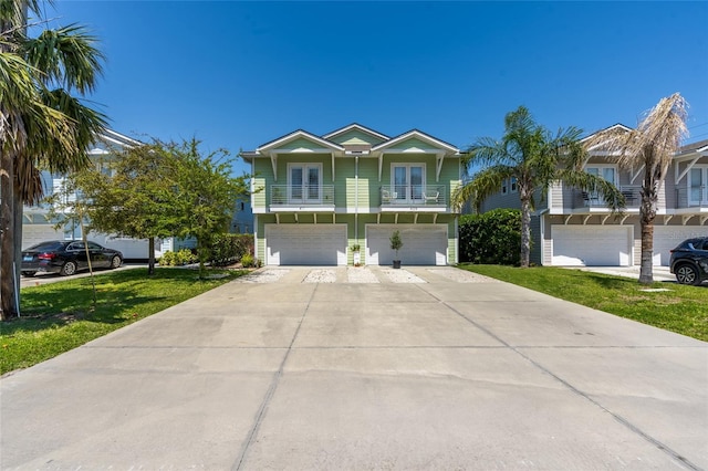 411 S 5th Ave S, Jacksonville Beach, FL 32250 - view of front of property with a balcony, an attached garage, a front lawn, and driveway