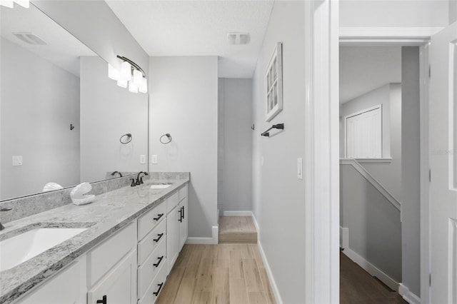 411 S 5th Ave S, Jacksonville Beach, FL 32250 - bathroom featuring baseboards, double vanity, a sink, and wood finished floors