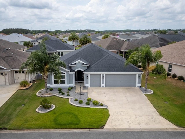 single story home with a garage, driveway, a shingled roof, a residential view, and a front lawn
