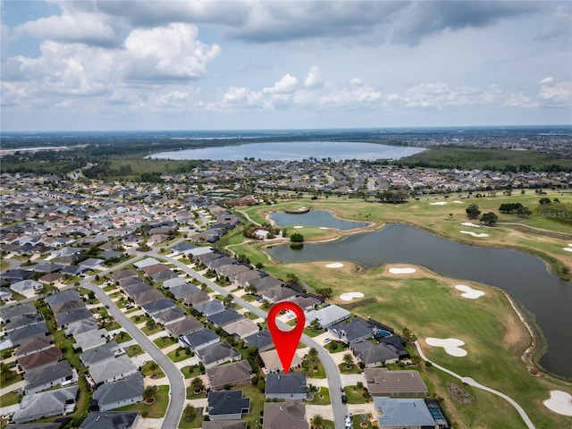 view of property location featuring nearby suburban area, a large body of water, and a local golf course