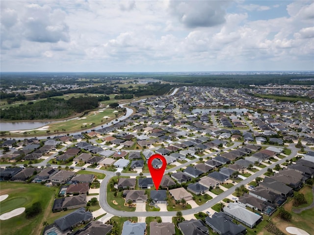 aerial view of property and surrounding area with nearby suburban area, a local golf course, and a nearby body of water