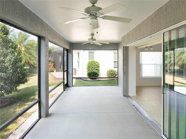 unfurnished sunroom featuring ceiling fan