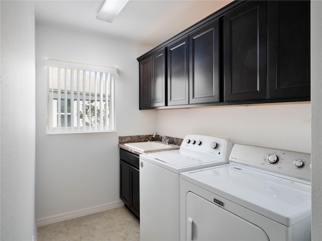 clothes washing area with washer and clothes dryer, cabinet space, baseboards, and light tile patterned floors