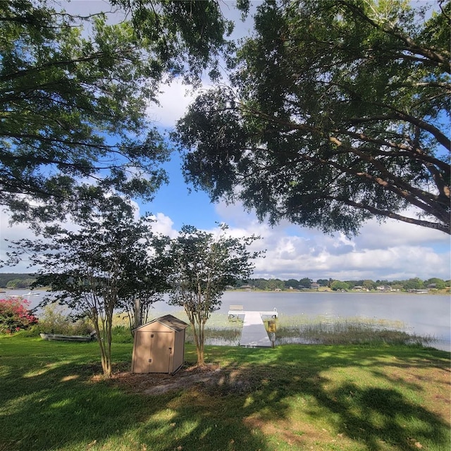 11024 Windchime Cir, Clermont, FL 34711 - view of green lawn with a water view, a shed, and a boat dock