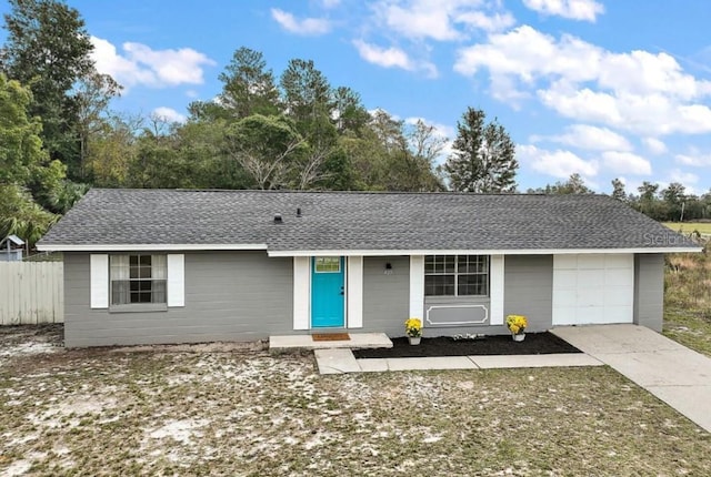 single story home with driveway, a shingled roof, fence, and an attached garage