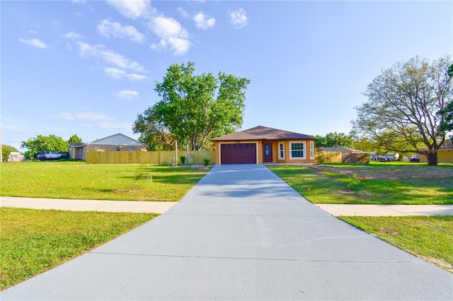 view of front facade with an attached garage, driveway, a front yard, and fence