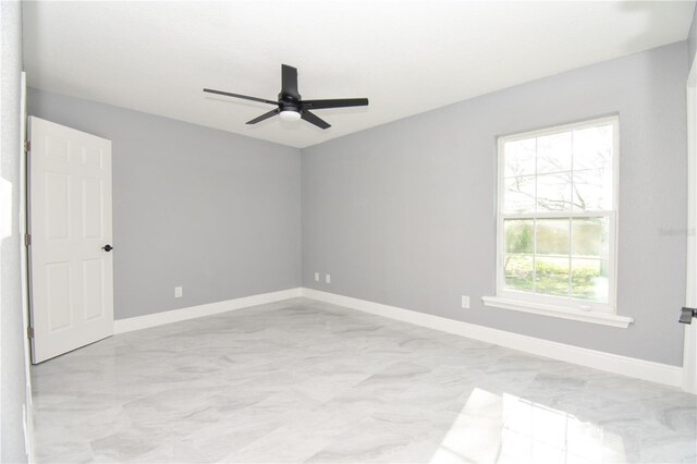 unfurnished room with baseboards and a ceiling fan