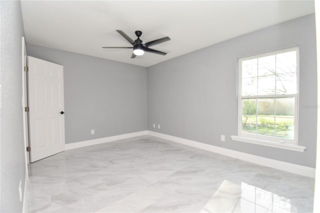 spare room featuring baseboards and a ceiling fan
