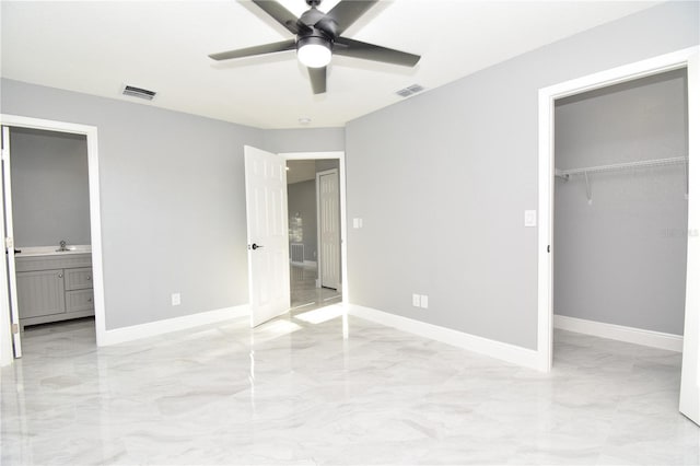 unfurnished bedroom with a closet, baseboards, a spacious closet, and visible vents